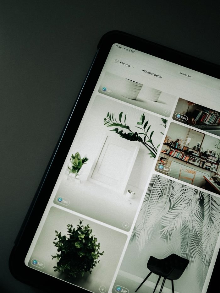 A tablet screen featuring images of minimalist decor emphasizing greenery and simple design.